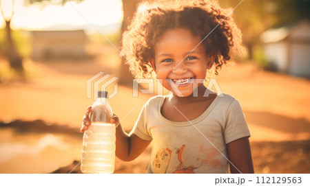 Poor, beggar, hungry smiling black child in Africa, thirsty to drink water from a plastic bottle. Poor, beggar, hungry smiling black child in Africa, thirsty to drink water from a plastic bottle. 112129563