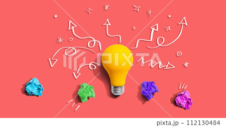 Brainstorming concept with a idea light bulb and crumpled paper Brainstorming concept with a idea light bulb and crumpled paper 112130484