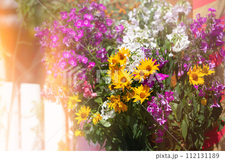 Floral background of a bouquet of chrysanthemums and petunias in a yellow haze. 112131189