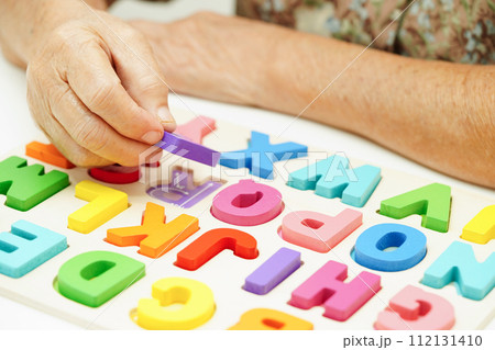 Asian elderly woman playing puzzles game for treatment dementia prevention and Alzheimer disease. 112131410