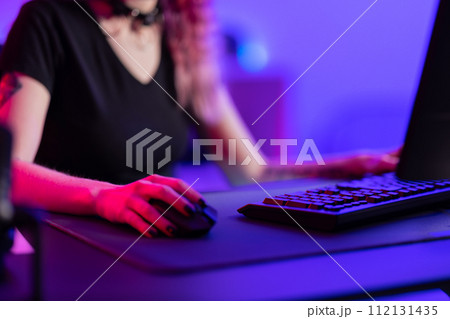 Focused Professional Gamer Playing in a Vibrant Gaming Room 112131435