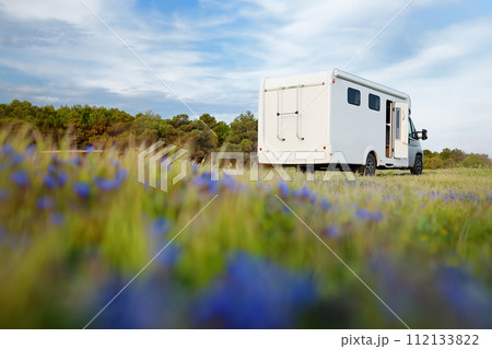 View of a large mobile home (design of van was changed during post processing ) parked in blooming meadow. Family vacation travel RV. Travel and adventure. Go everywhere 112133822