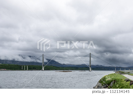 Lines of a suspension bridge frame a cloud-shrouded view along the Kystriksveien route Lines of a suspension bridge frame a cloud-shrouded view along the Kystriksveien route 112134145