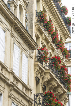 Beautiful parisian building decorated by red flowers; vertical picture 112134815