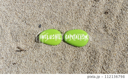 Inclusive capitalism symbol. Concept words Inclusive capitalism on beautiful green stone. Beautiful sand beach background. Business inclusive capitalism concept. Copy space. 112136798