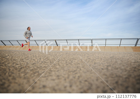 Fit man burning calories during morning jog, enjoying workout outdoor. People. Sport. Active healthy lifestyle concept. 112137776