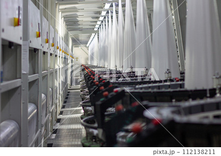 Interior of a factory shop. Equipment for weaving polypropylene fabric. Interior of a factory shop. Equipment for weaving polypropylene fabric. 112138211