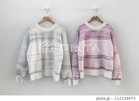 AI-generated content. Elegant striped sweaters hanging on the wall are a modern fashion statement for your fall/winter wardrobe. 112138473