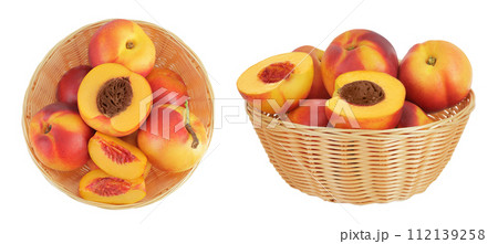 Ripe nectarine fruit with half in a wicker basket isolated on white background with full depth of field. Top view. Flat lay Ripe nectarine fruit with half in a wicker basket isolated on white background with full depth of field. Top view. Flat lay 112139258