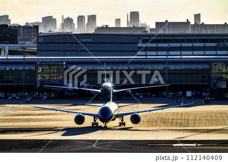 夕暮れの羽田空港　タキシング中の飛行機　東京都大田区 112140409
