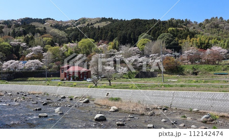 川沿いのレンガ造りの建物と桜咲く山　常陸太田市旧町屋変電所 112142474