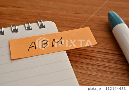 ABMと書かれた付箋とノートとペン ABMと書かれた付箋とノートとペン 112144488