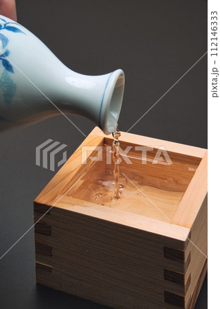 木でできた升に日本酒を注ぐ 112146333