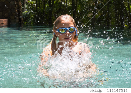 Teenage boy playing in swimming pool. 112147515