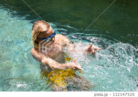Teenager has fun in the pool on vacation. Teenager has fun in the pool on vacation. 112147520