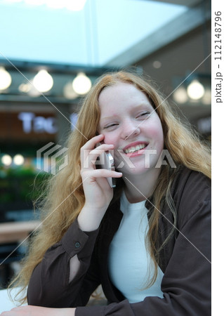 A young girl talking on the phone. Close-up of her face. High quality A young girl talking on the phone. Close-up of her face. High quality 112148796