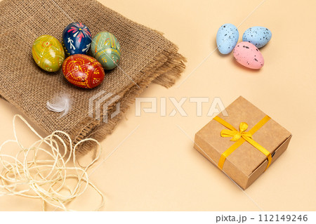 Easter eggs on a sackcloth bag and a gift box. Easter eggs on a sackcloth bag and a gift box. 112149246