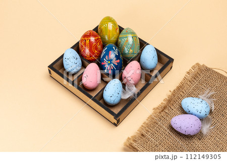 Colorful Easter eggs in a box and a sackcloth bag. Colorful Easter eggs in a box and a sackcloth bag. 112149305
