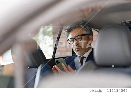 シニア男性　ビジネス　車内　スマホ 112154043