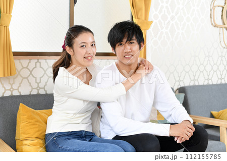 ソファーでハグするアジア人の男女カップル 112155785