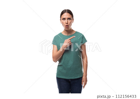 attractive young caucasian woman with black hair in a t-shirt points her hand to the side in 112156433