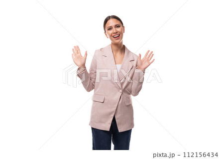 A cute young woman with black hair dressed in a beige jacket and jeans tells interesting news A cute young woman with black hair dressed in a beige jacket and jeans tells interesting news 112156434