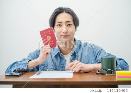 パスポートを手に取る若い男性 112156466
