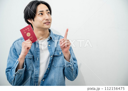 パスポートを手に取る若い男性 112156475