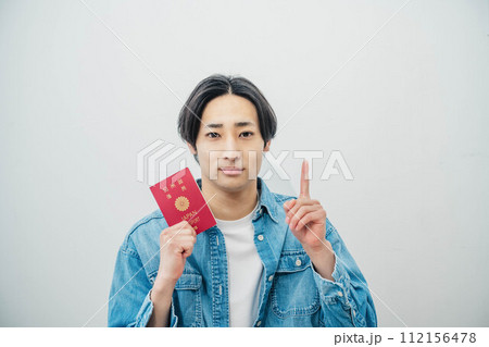 パスポートを手に取る若い男性 パスポートを手に取る若い男性 112156478