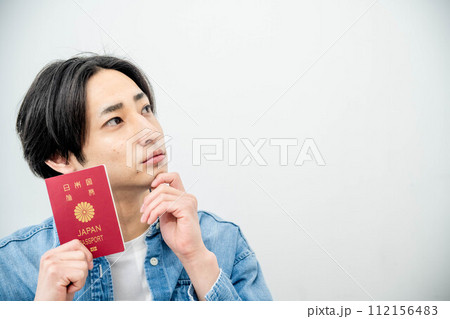 パスポートを手に取る若い男性 112156483