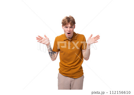young fashionable student man with short red hair dressed in a yellow t-shirt is actively gesturing 112156610