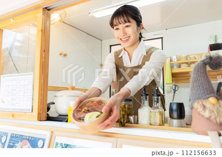 キッチンカー　ランチ　接客する女性 112156633