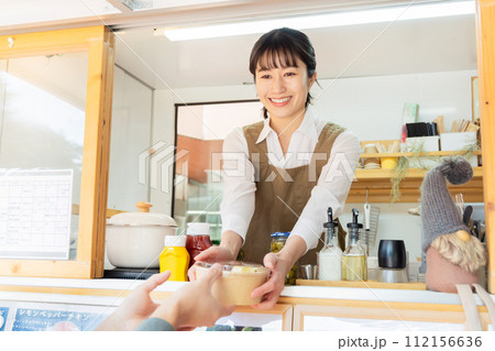 キッチンカー　ランチ　接客する女性 112156636