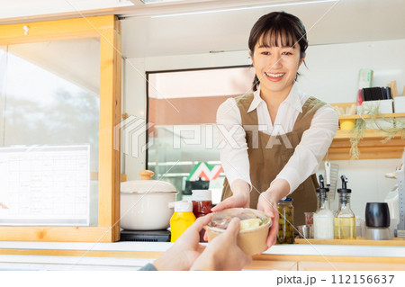 キッチンカー　ランチ　接客する女性 112156637