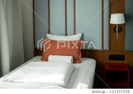 Bedroom modern design with furnishing. Interior of a double bed hotel room. Empty bed with disheveled pillow and sheets. 112157238