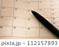 手帳のカレンダーとボールペン 112157893