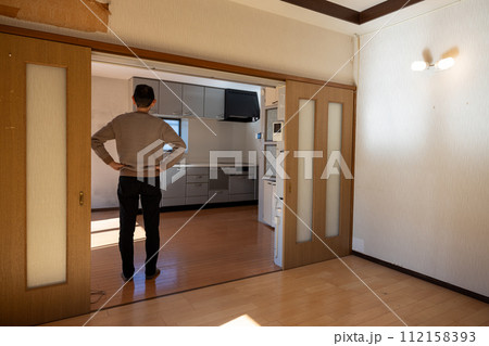 実家の遺品整理をして中の荷物をすべて運び出した後、部屋を見ている男性 112158393