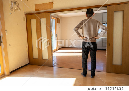 実家の遺品整理をして中の荷物をすべて運び出した後、部屋を見ている男性 実家の遺品整理をして中の荷物をすべて運び出した後、部屋を見ている男性 112158394