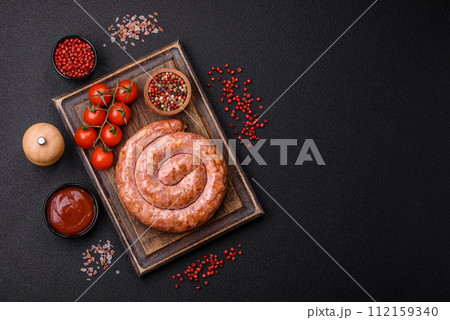 Delicious grilled sausage in the form of a ring with salt, spices and herbs Delicious grilled sausage in the form of a ring with salt, spices and herbs 112159340