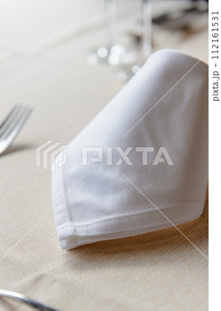 レストランのテーブルセッティング、テーブルに置かれたナプキンとカトラリー 112161531