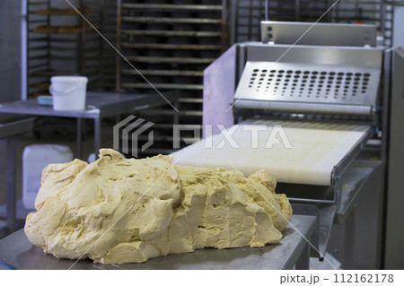 Industrial production of culinary products and bread.Yeast dough on the bread baking line Industrial production of culinary products and bread.Yeast dough on the bread baking line 112162178