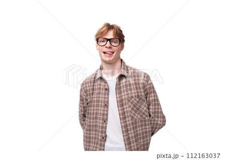 a young smiling man with red golden hair in glasses and a shirt stands alone on a white background 112163037