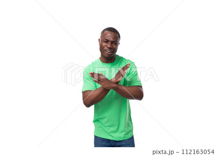 young confident american male advertiser dressed in green t-shirt with mockup gesturing 112163054