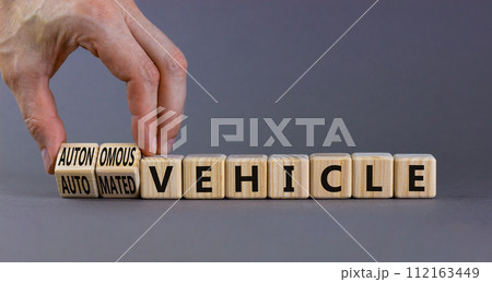Autonomous or automated vehicle symbol. Businessman turn cubes and changes words Automated vehicle to Autonomous vehicle. Grey background. Business Autonomous or automated vehicle concept, copy space. 112163449