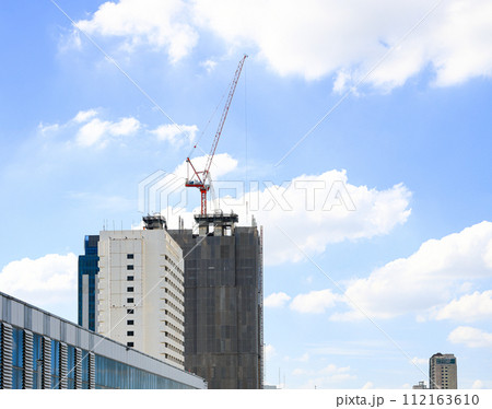 construction tower crane work with construction worker on top of building, used in construction site with blue sky. construction tower crane work with construction worker on top of building, used in construction site with blue sky. 112163610