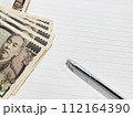 一万円札とノートとペン 112164390