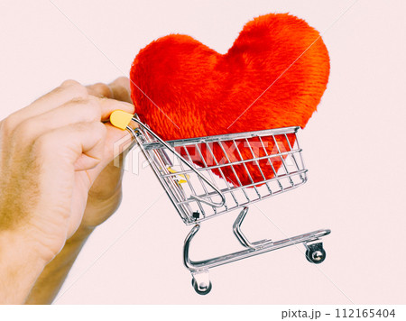 Male hands holding shopping cart with heart. Male hands holding shopping cart with heart. 112165404