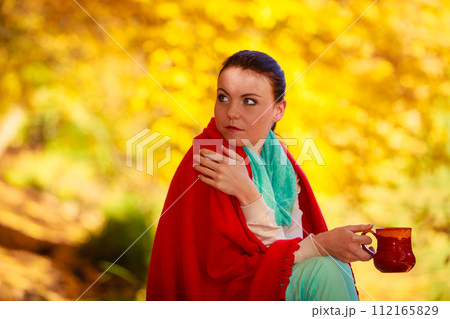 thoughtful girl in the autumn park enjoying hot drink thoughtful girl in the autumn park enjoying hot drink 112165829