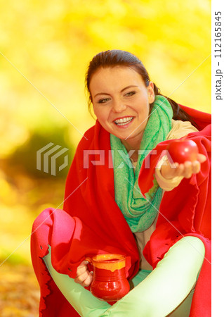 Woman relaxing in park drinking drink from mug Woman relaxing in park drinking drink from mug 112165845