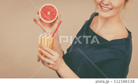 Happy woman holding fresh orange juice 112166138